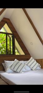 two books on a bed in a room with windows at Casa Maria at Bigang Munti in San Juan