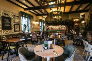 um restaurante com mesas e cadeiras e um bar em Rockingham Arms By Greene King Inns em Wentworth