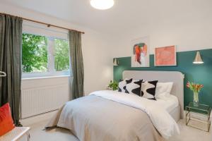 a bedroom with a white bed and a window at The Clissold, Two Bedroom Apartment N5 in London