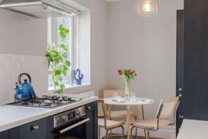 a kitchen with a stove and a table with chairs at The Clissold, Two Bedroom Apartment N5 in London