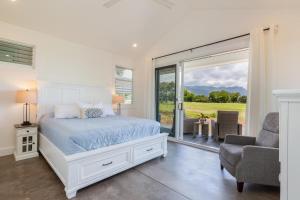 een slaapkamer met een bed en een glazen schuifdeur bij Kauai Tradewinds home in Princeville