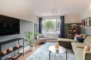 a living room with a couch and a tv at The Clissold, Two Bedroom Apartment N5 in London