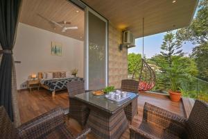 a room with a patio with a table and chairs at Elegant Villa By Tropicana Stays in Lonavala