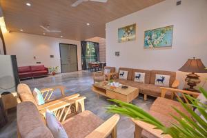 a living room with couches and a table at Elegant Villa By Tropicana Stays in Lonavala
