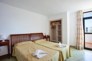 Łóżko lub łóżka w pokoju w obiekcie Apartamentos Don Quijote