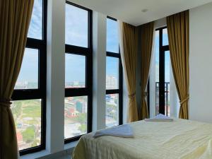 a bedroom with large windows and a bed in front thereof at The Vincent Condo in Phnom Penh