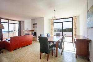 a dining room with a table and chairs and a desk at Apartamentos Don Quijote in Cala Ratjada