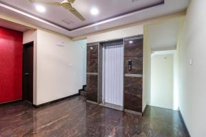 an empty room with a door and a red wall at Capital O N R Residency in Bengaluru