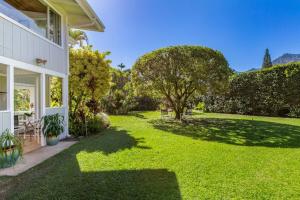 einen Hof mit grünem Gras und einem Haus in der Unterkunft Hanalei Hideaway home in Hanalei