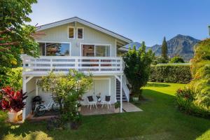 ein weißes Haus mit einer Veranda und 2 Stühlen in der Unterkunft Hanalei Hideaway home in Hanalei