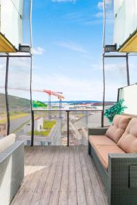 a balcony with a couch and a view of the ocean at Super Central Designer Penthouse at 19th floor with Amazing View! in Oslo