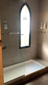 a bathroom with a glass shower with a window at Del Caballero Hotel in Villa La Angostura
