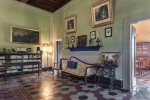 Habitación con sofá, mesa y piano en Villa Il Frassine, en Rignano sullʼArno