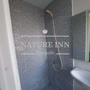 a bathroom with a shower with the words nature inn at NATURE INN Aeropolis AR3 in Tangerang +17 photos