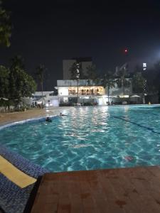 a swimming pool at night with people in the water at NATURE INN Aeropolis AR3 in Tangerang