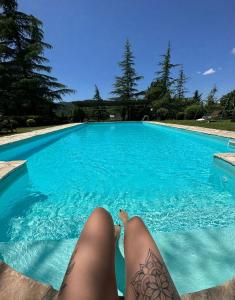 a person laying on the edge of a swimming pool at Dependance Giardino in Umbertide