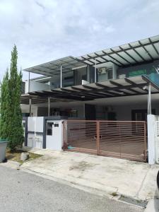 una casa con una valla de madera delante de ella en UG Homestay BP - Netflix & 4 Air-Con Rooms, en Batu Pahat