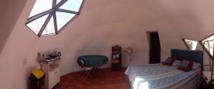 a bedroom with a bed and a window at Hermoso Domo privado para 2 personas con tinaja-Cochiguaz Valle De Elqui in Paihuano