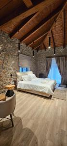 a bedroom with a large bed and a stone wall at Miltilon in Synikia Mesi Trikalon