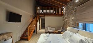 ein Schlafzimmer mit einem Bett und eine Treppe mit einem TV in der Unterkunft Miltilon in Synikia Mesi Trikalon