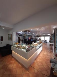 un homme se tient derrière un comptoir dans une boulangerie dans l'établissement Hotel Venezia, à Caorle