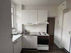 a kitchen with white cabinets and a stove top oven at STOCKHOLM APARTMENT & LIVING in Stockholm