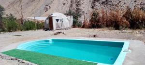 a swimming pool and a tent in the desert at Hermoso Domo privado para 2 personas con tinaja-Cochiguaz Valle De Elqui in Paihuano