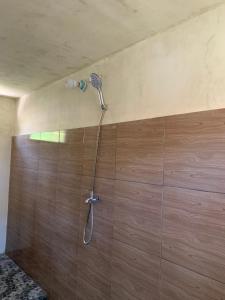 a shower with a shower head on a wall at Avocado homestay in Tetebatu