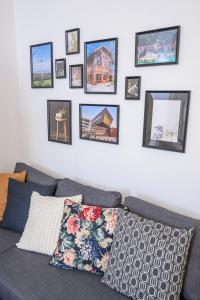 a living room with a blue couch and pictures on the wall at City Center Mödling in Mödling