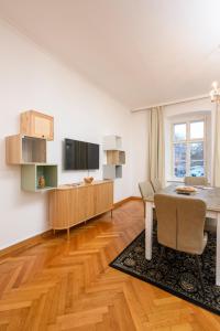 a living room with a table and a tv at City Center Mödling in Mödling