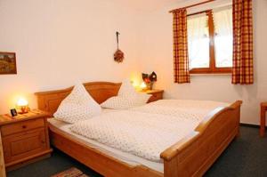 a bedroom with a wooden bed and a window at Haus Kaufmann in Bad Hindelang