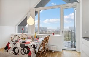 a dining room with a table and chairs and a large window at Beautiful Home In Skagen With Wifi in Skagen