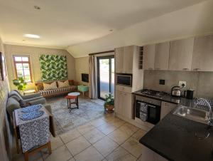 Una cocina y una sala de estar con un sofá. en 33 Longifolia, en Stellenbosch 7 fotos más