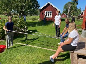 a group of children playing a game of limbo at Äventyrsgårdens Vandrarhem, Kinnekulle in Källby