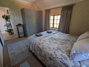 Un dormitorio con una cama grande y una ventana. en 33 Longifolia, en Stellenbosch