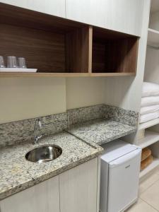 uma cozinha com um lavatório e uma bancada em Spazzio diRoma Acesso Gratuito ao Aqua Park em Caldas Novas