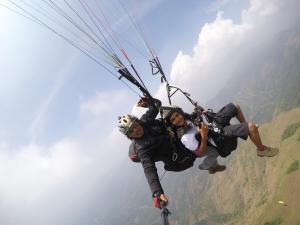 twee mensen op een parachute in de lucht bij The Kissing Mountains in Vagamon
