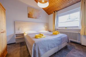 a bedroom with a bed with yellow towels on it at Ferienhaus Schöne Aussicht Ferienwohnung Gelb in Hemfurth-Edersee