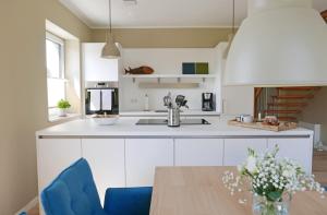 a kitchen with white cabinets and a wooden table at Borbyer Perle in Eckernförde