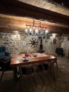 une salle à manger avec une table en bois et un lustre dans l'établissement GUEST HOUSE PRIVAL.CLUB, à Žabljak