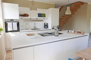 a kitchen with white cabinets and a staircase at Borbyer Perle in Eckernförde