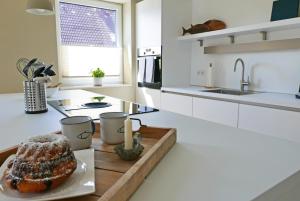 a white kitchen with a cake on a cutting board at Borbyer Perle in Eckernförde