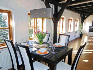 a dining room with a black table and chairs at Über dem Kattsund in Eckernförde