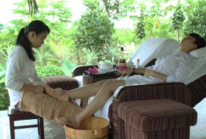 een vrouw die in een stoel met een man praat bij Mekong Riverside Boutique Resort & Spa in Cai Be