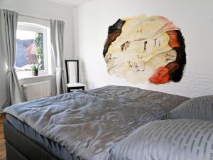 une chambre avec un lit avec un tableau sur le mur dans l'établissement Über dem Kattsund, à Eckernförde