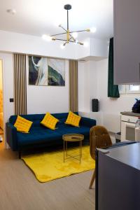 - un salon avec un canapé bleu et des oreillers jaunes dans l'établissement Résidence Peace, au Bourget