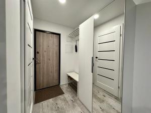 un pasillo con una puerta y un banco en una habitación en Уютная квартира в центре, en Klaipėda