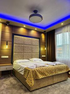 ein Schlafzimmer mit einem großen Bett mit blauer Beleuchtung in der Unterkunft Hotel Diamant in Dospat