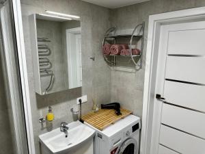 y baño con lavabo y lavadora. en Уютная квартира в центре, en Klaipėda