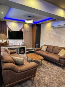 ein Wohnzimmer mit 2 Sofas und einem TV in der Unterkunft Hotel Diamant in Dospat
